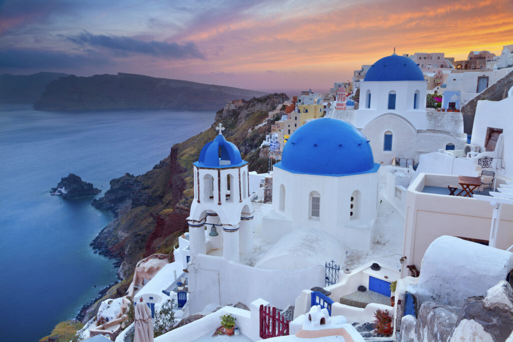 Image of small village Oia, located on beautiful greek island Santorini, during sunset.